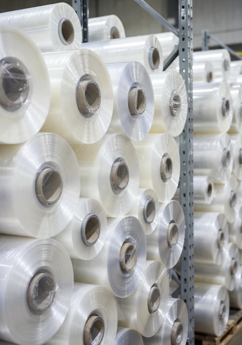 Cold Laminator Supplies. Close-up of Cold Laminator Supplies including glossy film rolls, self-seal pouches, and a 25-inch cold laminator applying pressure-sensitive adhesive to a poster