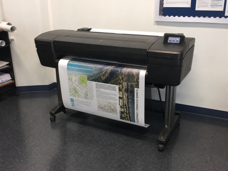 Teacher using a poster printer machine to create educational classroom posters and school visuals
